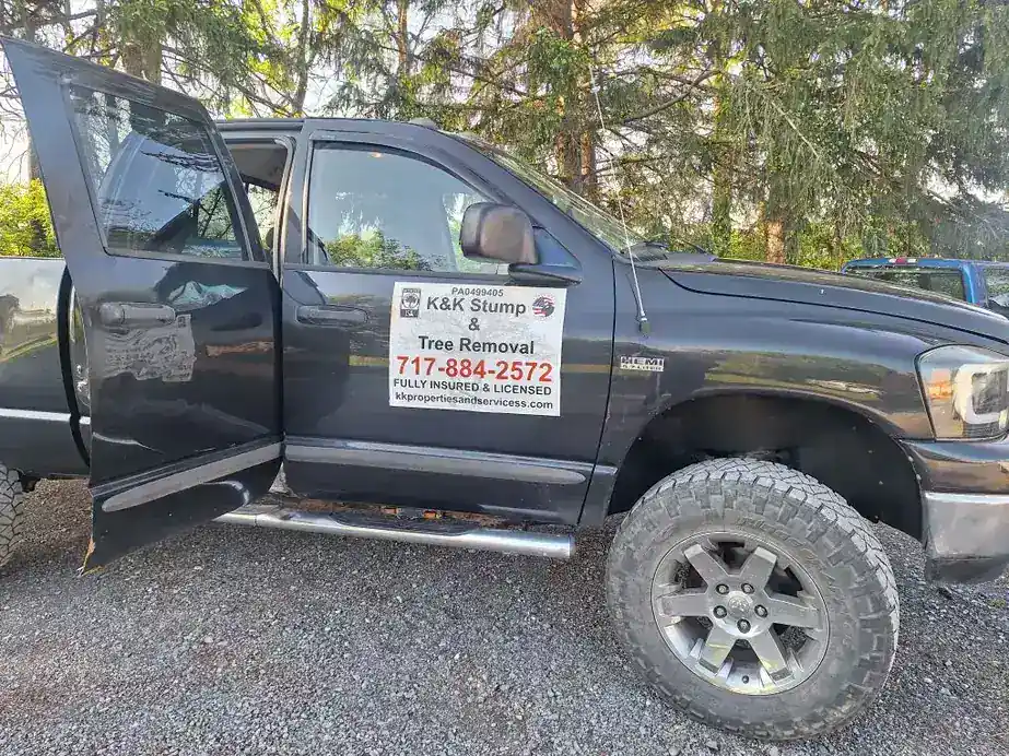 Black K&K pickup with the K&K Stump and Tree Removal sign on the door